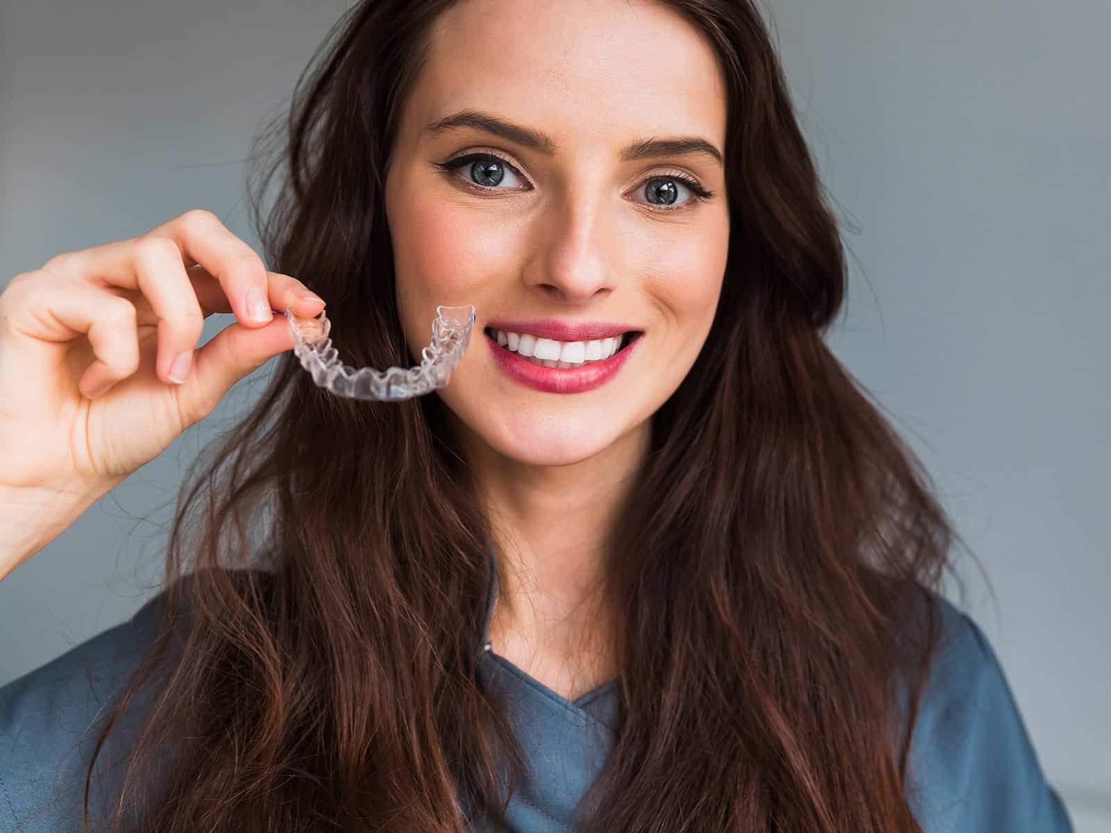 Woman holding clear aligner