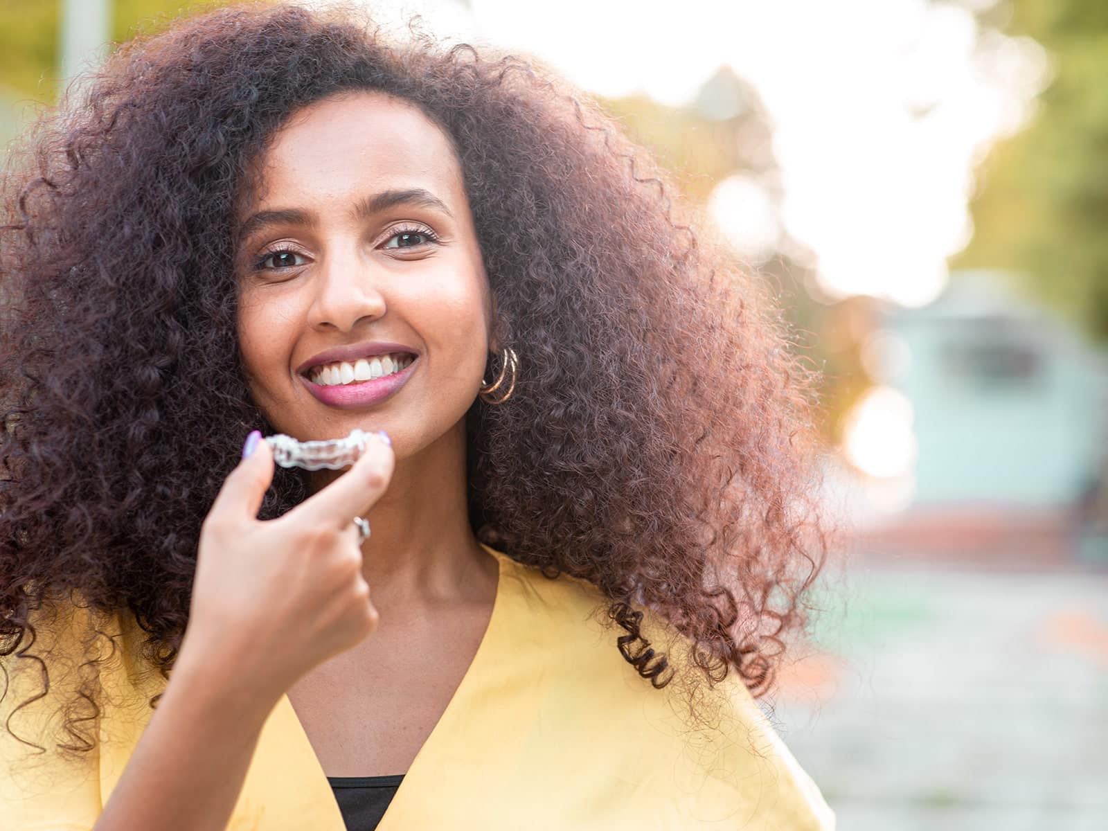 Woman showing off her clear aligner