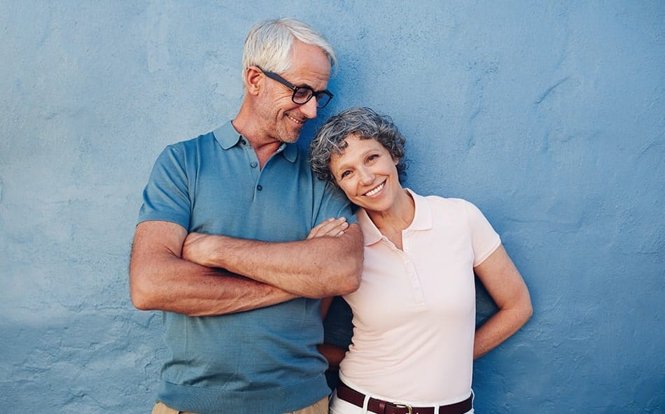 benefits-of-snap-on-dentures-2 senior couple standing outdoors smiling at the camera