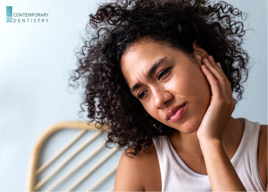 TMJ Woman holding her jaw due to TMJ-related jaw pain